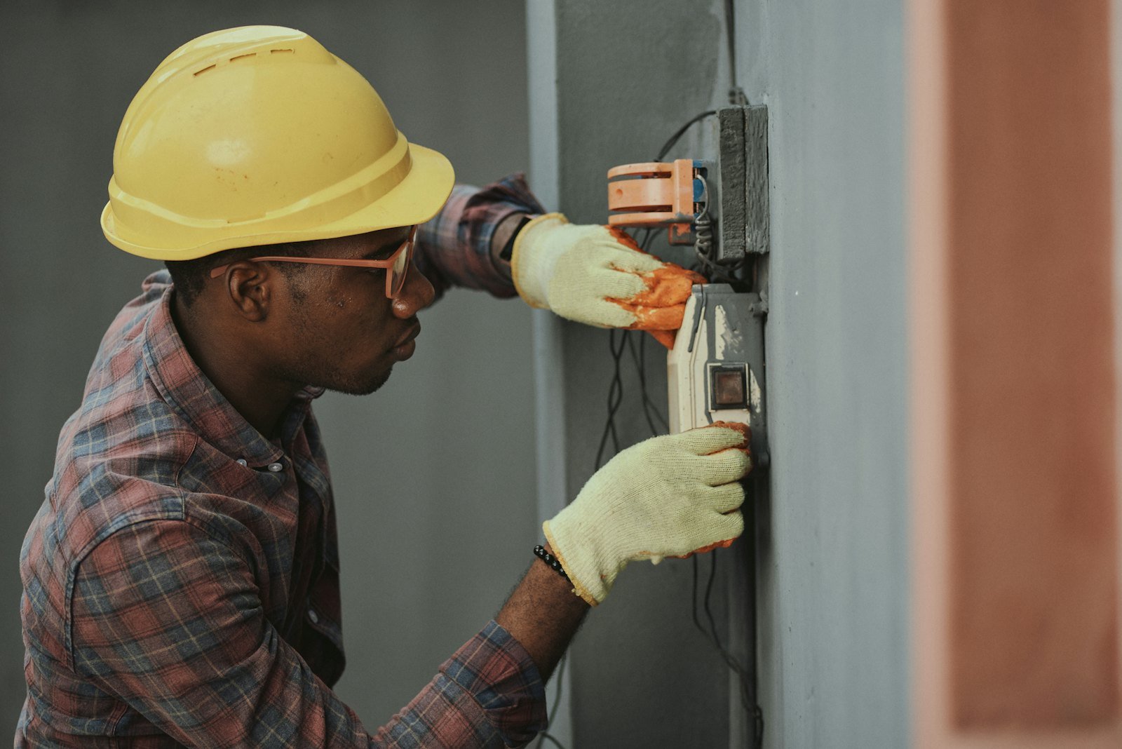 Tradesman in a hard hat repairing a wall on a job site